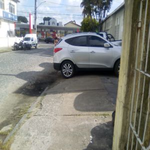 Carros em cima da calçada