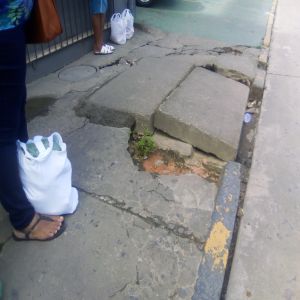 Calçada danificada e rede entupida