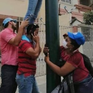 Minha pergunta é: O que a senhora do boné está fazendo?