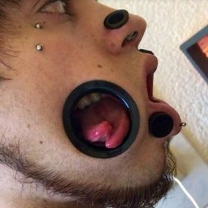 Jovem abre buraco no rosto para permitir que dentes e língua sejam vistos pela bochecha